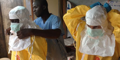 Health workers suiting up in hazmat gear. Scene from an Ebola outbreak containment team.