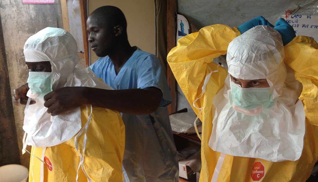 Health workers suiting up in hazmat gear. Scene from an Ebola outbreak containment team.