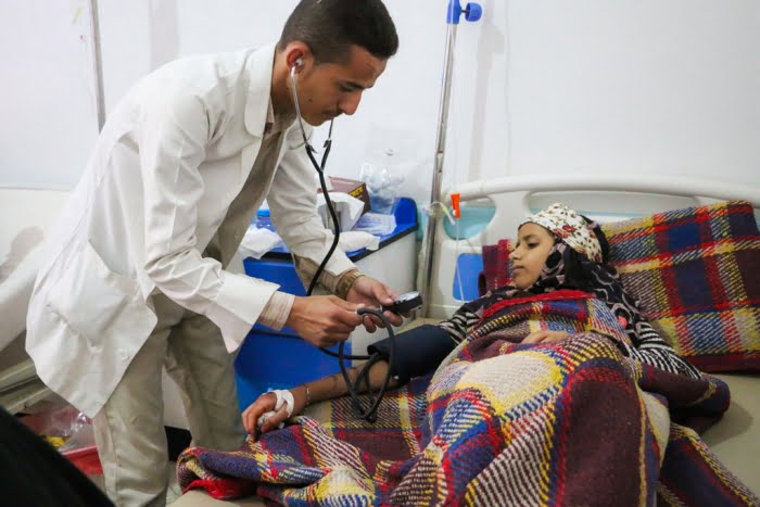 Doctor checking vitals of a non-contagious women with Cholera in Al Sab’een Hospital, Yemen