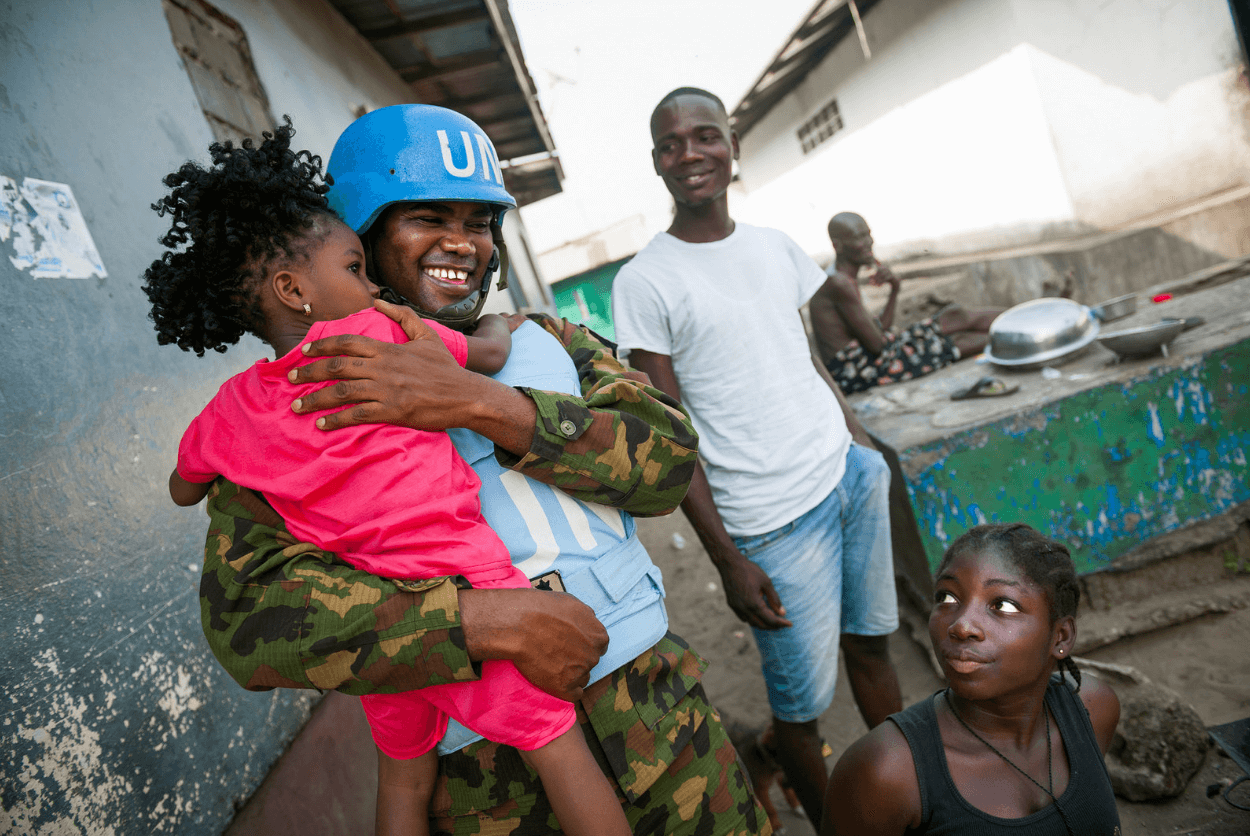 Captain Joseph Eranga, a Nigerian peacekeeper serving with UNMIL, holds a child during an evening patrol in Monrovia. UN Photo/Albert González Farran 12 January 2018 Monrovia, Liberia
