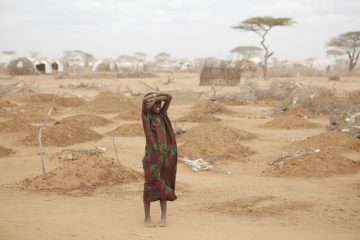 Girl stands amid the 70 graves of children that died during the long desert journey to relief camps in Dadaab.