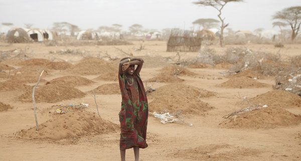 Girl stands amid the 70 graves of children that died during the long desert journey to relief camps in Dadaab.